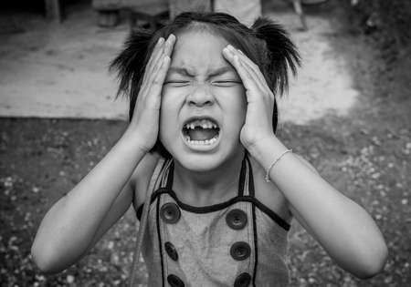 Closeup smiling little asian girl with a broken teethの写真素材