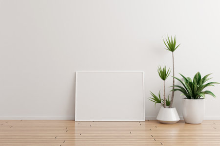 White horizontal photo frame mockup on white wall empty room with plants on a wooden floorの写真素材