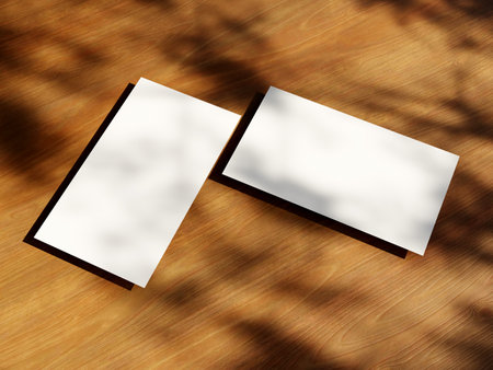 Clean minimal business card mockup with the leaves shadow on wood table backgroundの写真素材