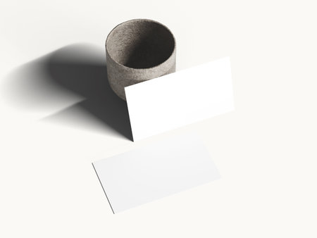 Clean white business card mockup on soft surface with gentle shadow.の写真素材
