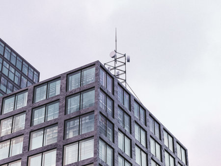 Urban glass building reflecting soft pastel sky in its windows.