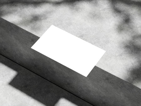 Minimalistic business card mockup on concrete with subtle shadow play.の写真素材