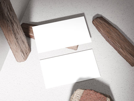 Business card placed on a stone surface with wooden logs, giving an earthy and natural feel.の写真素材