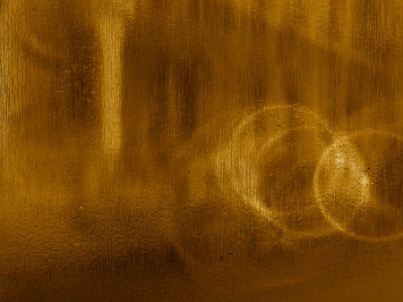 Rich golden texture with soft blurred light spots and intricate scratch marks.