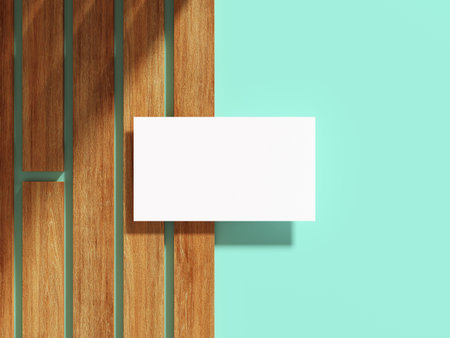 White business card on a wooden surface with flat background.の写真素材