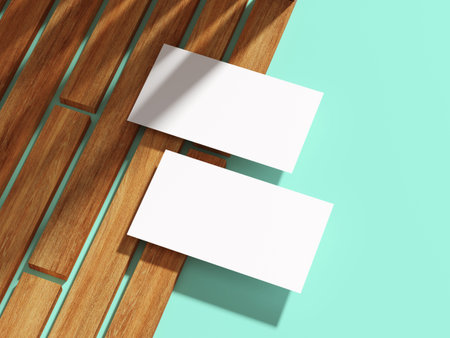 A white business card placed diagonally on wooden planks with flat backdrop.の写真素材