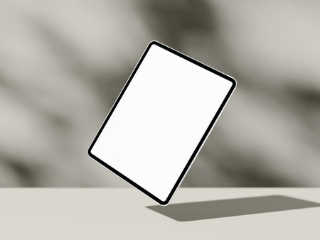 Floating angled tablet screen mockup with shadow on beige abstract surfaceの写真素材