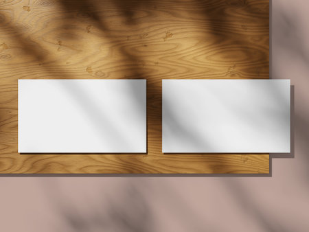 Business cards on a wooden plate with a smooth shadow and minimalist setup.の写真素材