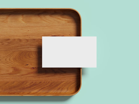 Minimalist business card placed on a wooden tray with a soft background.の写真素材