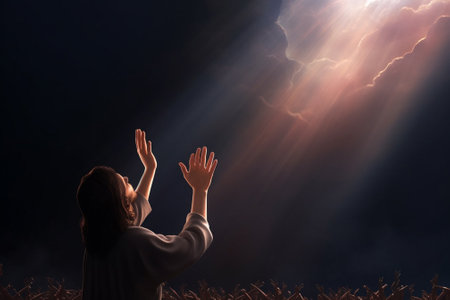 Young woman praying in front of a dark sky with rays of lightの素材