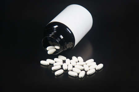 white pills with bottle black backgroundのeditorial素材