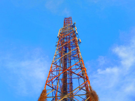 Telecommunication tower with blue sky background, closeup of photo.