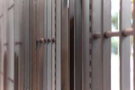 iron bars, metal grating or prison cell, bright blurred outdoor backgroundの写真素材