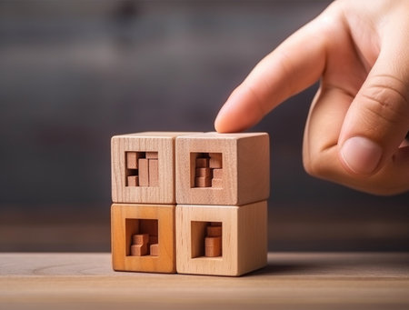 Close-up Of Person's Hand Building House From Wooden Cubesの素材