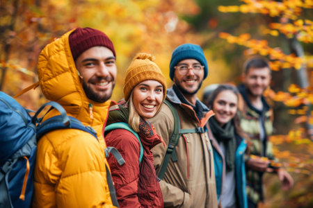 Group of friends hiking in autumn forest. They are smiling and looking at camera.の素材