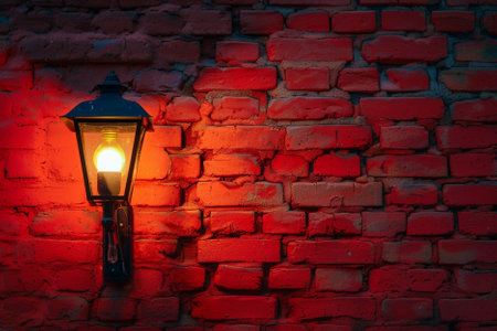 Lantern on a brick wall with red light at night.の素材