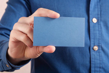 Hand holding blank business card isolated on white Minimal flat backgroundの写真素材