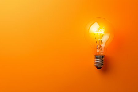 Light bulb on orange background. Concept of idea, innovation and creativity.の写真素材