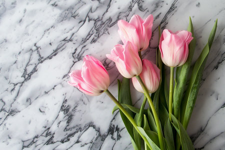 Bouquet of pink tulips on a white marble background.