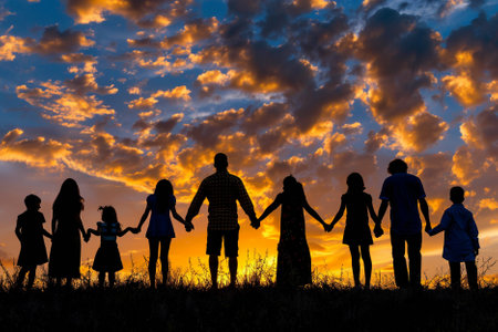 Silhouette of happy family holding hands on sunset sky background.の写真素材