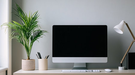 Workplace with computer, stationery and plant on table in room