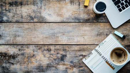 Overhead view of notepad with coffee cup and laptop on wooden table
