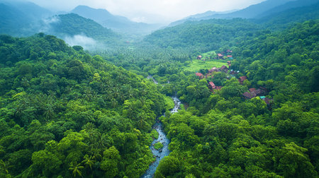 Beautiful aerial view of a small village surrounded by green forest and river.の写真素材