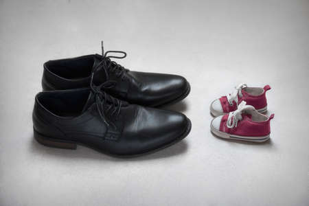 Father with Child Metaphor, baby and adult shoesの写真素材