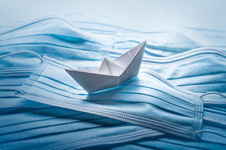 Pandemic problems concept, origami ship with surgical masks.の写真素材