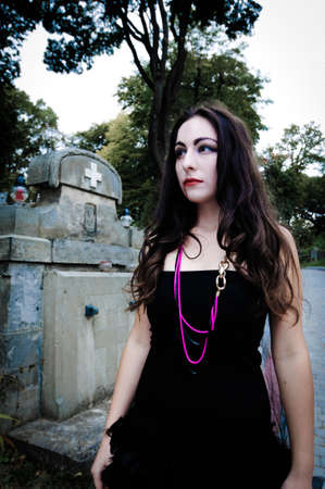 Pretty vampire near charnel house walking through graveyardの写真素材