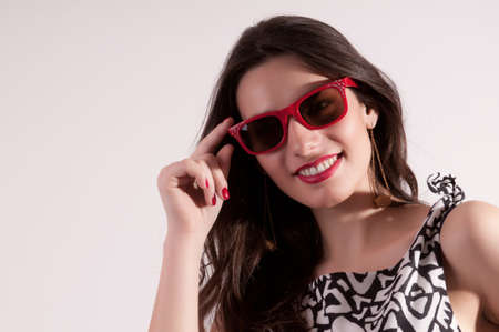 Pretty smiling woman in red sunglassesの写真素材