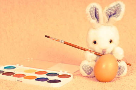 Easter rabbit in retro photo effect going to paint eggsの写真素材