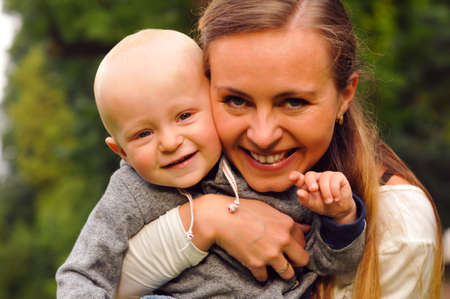 Happy mother with child smiling and looking at camera