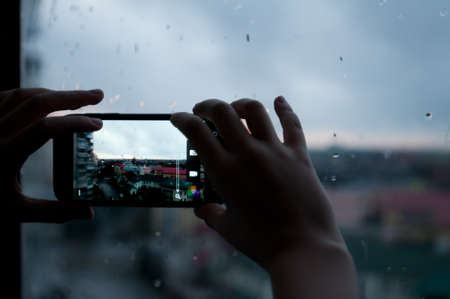 Closeup girl's hands taking photo with smartphoneの写真素材
