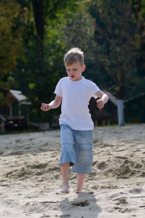 Dancing boy on the beach in white t-shirtの写真素材