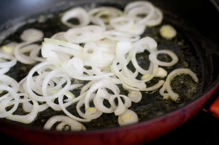 Onion is frying on pan red colorの写真素材