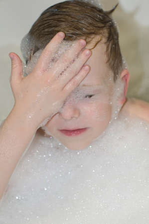 Six years child boy bathing with foam closeup portraitの写真素材
