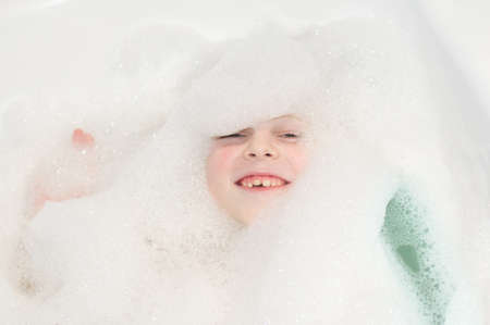 Six years child boy bathing with foam closeup portraitの写真素材