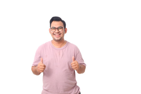 Portrait of happy asian male wearing glasses and purple shirt standing while showing thumbs up. Isolated on whiteの写真素材