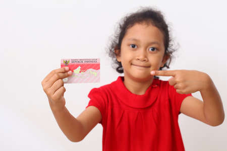 Yogyakarta, Indonesia - Dec 18, 2020 : Adorable Asian kids holds "Kartu Identitas Anak (KIA)" or Children Identity Card for Indonesian children.のeditorial素材