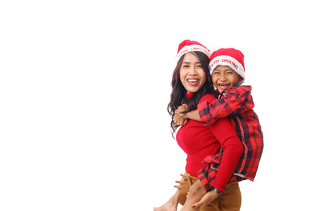 Beautiful asian young mother standing while carrying her son. Christmas concept. Isolated on white...