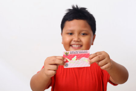Yogyakarta, Indonesia - Dec 18, 2020 : Adorable Asian kids holds "Kartu Identitas Anak (KIA)" or Children Identity Card for Indonesian children.のeditorial素材