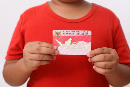 Yogyakarta, Indonesia - Dec 18, 2020 : Adorable Asian kids holds "Kartu Identitas Anak (KIA)" or Children Identity Card for Indonesian children.のeditorial素材