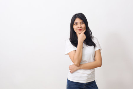 Portrait of beautiful asian woman with white shirt standing while looking away isolated on white background with copyspaceの写真素材