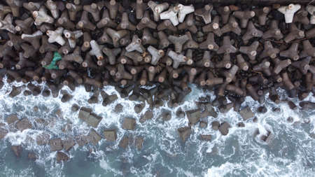 Aerial view of sea wave crashing tetra concrete block or wave breaker stoneの写真素材