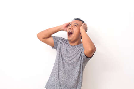 Wow and shocked face of Asian man point to present an empty space of content. Advertising model...