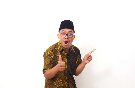 Wow and shocked face of Asian man point to present an empty space of content. Advertising model concept.の写真素材