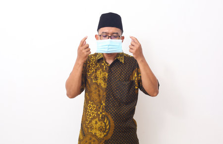 Portrait asian man standing while using a face mask. Isolated on white backgroundの写真素材