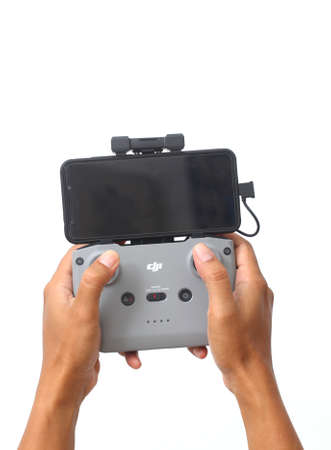 Yogyakarta, Indonesia - Mar 10, 2021 : Man's hand holding a DJI Drone Remote Controller with blank...