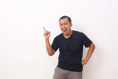 Wow and shocked face of Asian man point to present an empty space of content. Advertising model concept.の写真素材